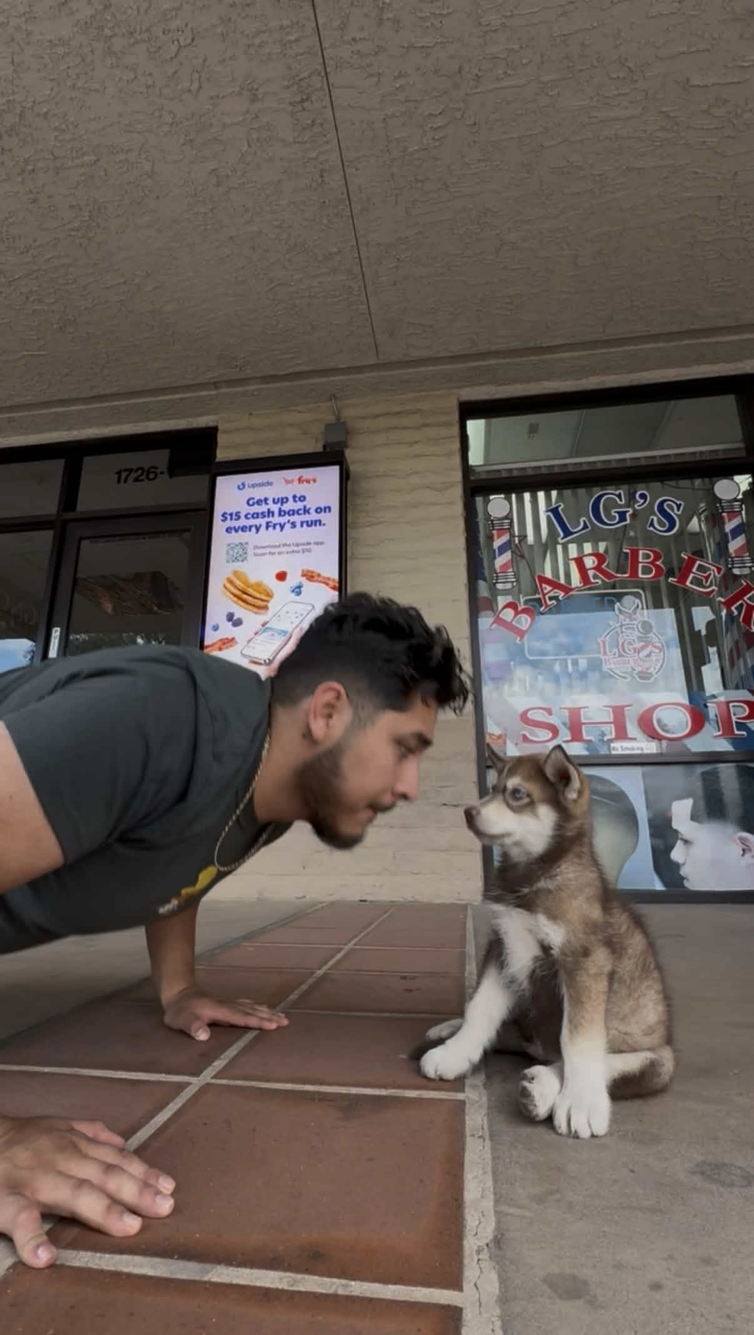 Balto the LG's Barber Shop mascot greeting a customer outside the Tempe shop